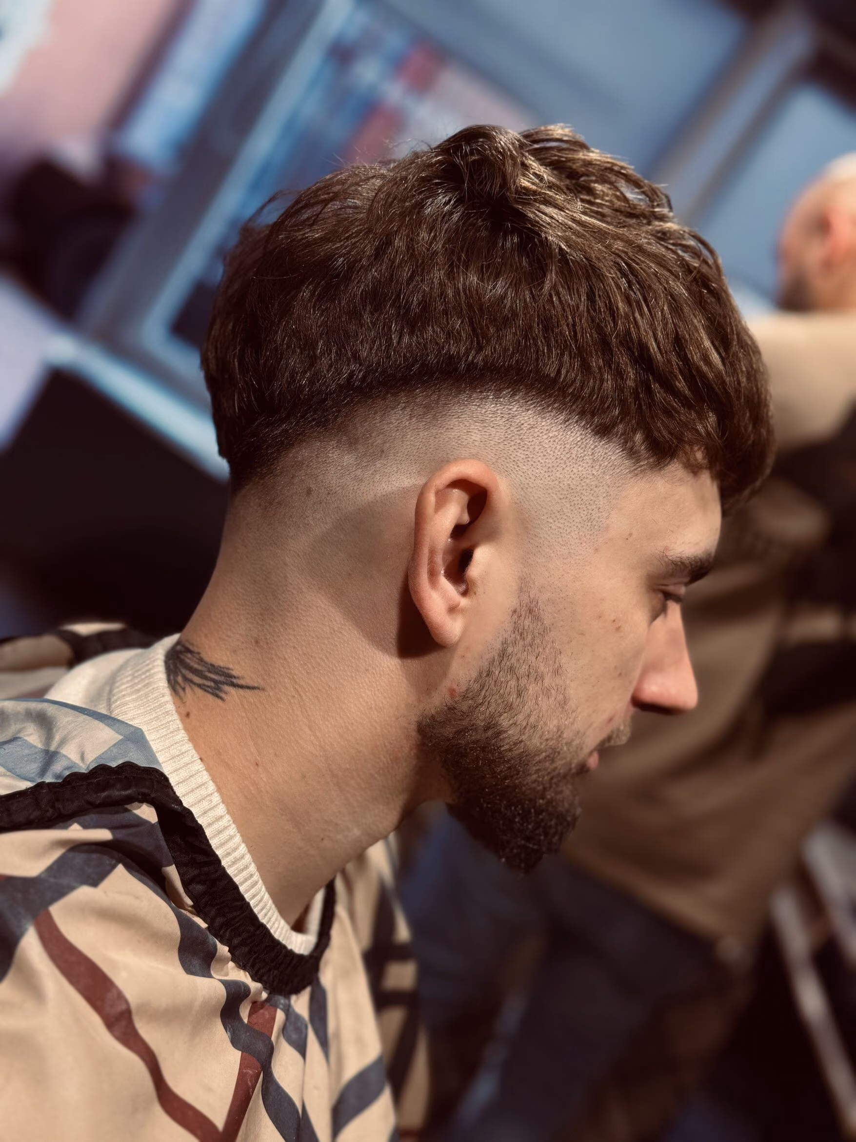Teksturowany crop z wysokim fade'em i krótką brodą