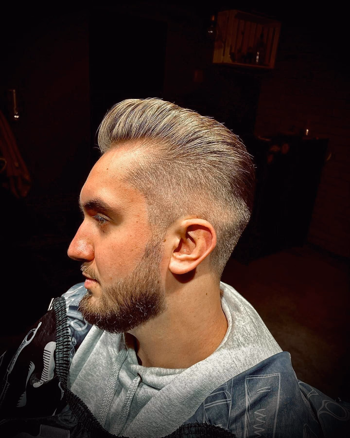 Zaczesany do góry quiff z fade'em i brodą